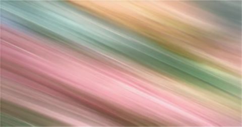 A blurred, painterly photograph of soft flowing light in sage green and pink, suggesting motion and change.